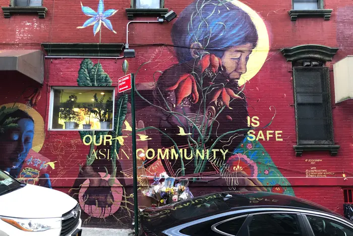 A mural on Mosco Street contains a plea to end anti-Asian hate crime. It also has become a memorial for Christina Yuna Lee, an Asian American woman who was murdered in her nearby apartment.